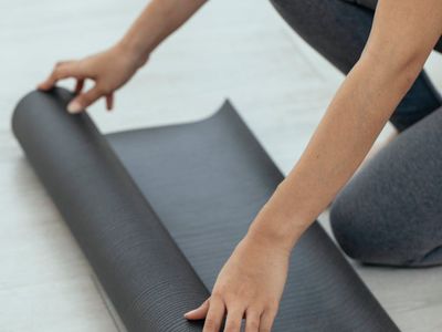 A yoga mat rolled out on a wooden floor, ready for practice.